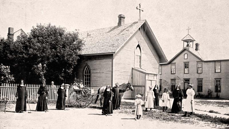 1878年宗教人士站在教堂外和马车前的照片.